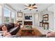 Spacious living room with a fireplace, ceiling fan, and comfortable seating, perfect for relaxation at 201 Shenandoah Way, Brighton, CO 80603