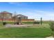 Community playground with slide and benches is surrounded by green grass and landscaping at 201 Shenandoah Way, Brighton, CO 80603