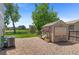 Charming shed with painted details, surrounded by gravel and greenery at 201 Shenandoah Way, Brighton, CO 80603