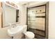 Cozy basement bathroom with sink, toilet, and shower featuring modern glass doors at 17212 E Oberlin Pl, Aurora, CO 80013
