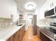 Stylish kitchen features white cabinets, wood accents, and quartz countertops at 17212 E Oberlin Pl, Aurora, CO 80013