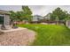 Expansive backyard with a lush lawn, rock bed, wooden fence, and privacy trees at 5136 S Ceylon St, Centennial, CO 80015