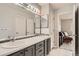 Bathroom features dual sinks, shaker cabinets, and a large mirror with vanity lighting at 5136 S Ceylon St, Centennial, CO 80015