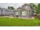 Back exterior of home has a lovely yard with stone accents, grass, and mature trees at 5136 S Ceylon St, Centennial, CO 80015