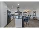 Well-lit kitchen featuring a modern island with seating, white cabinetry, and stainless steel appliances at 8092 S Jay Dr, Littleton, CO 80128