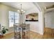 Bright dining area features a modern chandelier and access to a contemporary kitchen through an open archway at 1727 Pearl St # 205, Denver, CO 80203