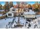 Aerial view of a charming two-story home with a snow-covered yard at 6144 S Fulton St, Englewood, CO 80111