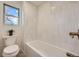 Clean bathroom with white tile and bathtub at 6144 S Fulton St, Englewood, CO 80111