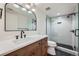 Modern bathroom with subway tile, a glass shower, and dark wood vanity at 6144 S Fulton St, Englewood, CO 80111