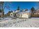 White two-story house with attached garage and snowy yard at 6144 S Fulton St, Englewood, CO 80111