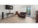 Bright living room featuring a brown leather sofa, a TV, and access to the balcony at 9150 E Center Ave # 7C, Denver, CO 80247