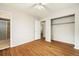 This is a bedroom with hardwood floors, a ceiling fan, closet, and entry to an adjacent room at 396 S Troy St, Aurora, CO 80012