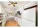 Open kitchen includes white cabinets and appliances, neutral countertops, and access to living room at 396 S Troy St, Aurora, CO 80012