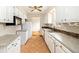 Bright kitchen features tile floor, white cabinets, neutral countertops and stainless steel appliances at 396 S Troy St, Aurora, CO 80012