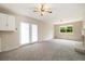 Cozy living room has neutral carpet, ceiling fan, a window with trees, and a fireplace at 396 S Troy St, Aurora, CO 80012