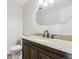 Bathroom with granite countertop, dark wood vanity, and updated fixtures at 8566 Flintwood Rd, Parker, CO 80138