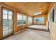 Bright sunroom with wood paneling, large windows, and access to outdoor space at 8566 Flintwood Rd, Parker, CO 80138