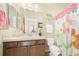 Bathroom with floral shower curtain, wood vanity, and large mirror at 10328 Bluffmont Dr, Lone Tree, CO 80124