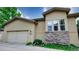 Home exterior showcasing a two-car garage, stone accents, and well-maintained landscaping at 10328 Bluffmont Dr, Lone Tree, CO 80124