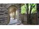 Covered front porch featuring arched columns and stone accents, complemented by mature trees at 10328 Bluffmont Dr, Lone Tree, CO 80124