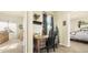 Home office space featuring a desk, adjacent room with large window, and neutral color palette at 10328 Bluffmont Dr, Lone Tree, CO 80124