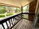 Balcony featuring wooded flooring, wooden railing, and views of the parking and greenery at 1870 S Pitkin Cir # B, Aurora, CO 80017