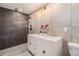 This modern bathroom has a double vanity, sleek tile, and a shower with a rainfall showerhead at 2395 W Davies Ave, Littleton, CO 80120