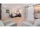 This bright main bedroom features a sliding barn door to the ensuite, natural lighting, and hardwood floors at 2395 W Davies Ave, Littleton, CO 80120