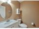 Small bathroom with a toilet, sink, mirror, and storage, maximizing space and function at 479 W Jamison Cir, Littleton, CO 80120