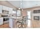 Eat-in kitchen featuring stainless steel appliances, granite countertops, and a cozy fireplace at 479 W Jamison Cir, Littleton, CO 80120