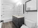 Bathroom features a tub and shower combination, vanity and framed mirror at 9044 E Nassau Ave, Denver, CO 80237