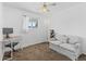 Bedroom featuring a small desk, light gray couch and view of the yard at 9044 E Nassau Ave, Denver, CO 80237
