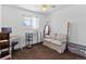 This bedroom includes neutral carpet, white walls, a desk, and a love seat at 9044 E Nassau Ave, Denver, CO 80237