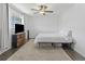 Bright bedroom features a ceiling fan, tv and modern wood furniture at 9044 E Nassau Ave, Denver, CO 80237