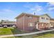 Exterior view of the two-story brick home with adjacent parking area and well-kept lawn at 9044 E Nassau Ave, Denver, CO 80237