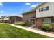Charming exterior of a red brick home with a well-manicured lawn and sidewalk leading to the entrance at 9044 E Nassau Ave, Denver, CO 80237