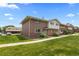 Exterior shot of a well-kept home with brick facade and lush green lawn on a bright, sunny day at 9044 E Nassau Ave, Denver, CO 80237
