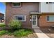 Charming brick home with a well-maintained front yard and a welcoming entrance adorned with hanging flower baskets at 9044 E Nassau Ave, Denver, CO 80237