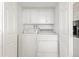 Laundry room features a washer, dryer and overhead storage at 9044 E Nassau Ave, Denver, CO 80237