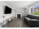 Modern living room showcasing sleek hardwood floors, a stylish fireplace, and abundant natural light from the window at 9044 E Nassau Ave, Denver, CO 80237