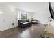 Bright, modern living room with hardwood floors and comfortable seating bathed in natural light from a large window at 9044 E Nassau Ave, Denver, CO 80237