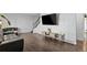 Bright living room with dark wood floors, neutral walls, a large TV, and comfortable seating at 9044 E Nassau Ave, Denver, CO 80237