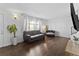 Spacious living room featuring dark wood floors, neutral walls, a large TV, and comfortable seating at 9044 E Nassau Ave, Denver, CO 80237
