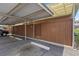 Covered parking area featuring a numbered unit entrance and painted parking restrictions at 9044 E Nassau Ave, Denver, CO 80237