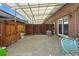 Covered patio with a wooden fence, brick walls, and concrete flooring is perfect for outdoor living at 9044 E Nassau Ave, Denver, CO 80237