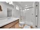 Modern bathroom featuring wood cabinets, granite countertop, large mirror, and glass-enclosed shower, offering luxury at 210 S Old Hammer Ct, Aurora, CO 80018