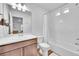 Bathroom featuring a combined tub and shower, wood cabinets, and a large mirror, creating a relaxing atmosphere at 210 S Old Hammer Ct, Aurora, CO 80018