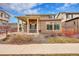 Charming two-story home with a covered porch, stone accents, and manicured landscaping at 210 S Old Hammer Ct, Aurora, CO 80018