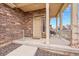 Inviting front porch featuring stone accents, covered entry and neutral colors at 210 S Old Hammer Ct, Aurora, CO 80018