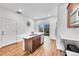 Bright kitchen with stainless steel appliances, center island, white countertops, wood cabinets, and sliding glass door to the yard at 210 S Old Hammer Ct, Aurora, CO 80018